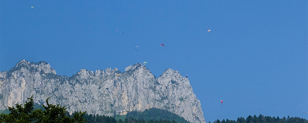 De ruigere oostkant van meer van Annecy, met de paragliders hoog boven je De ruigere oostkant van meer van Annecy